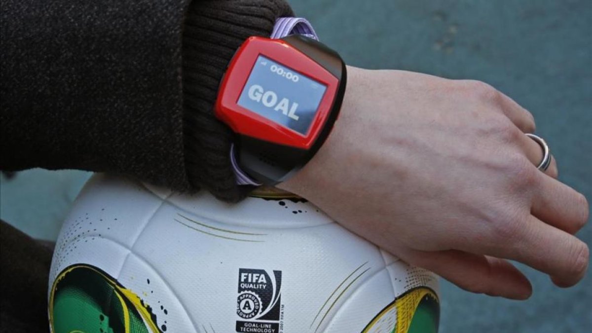 Un árbitro muestra el reloj que indica que la pelota ha entrado.-SHUJI KAJIYAMA