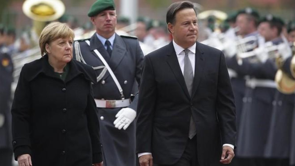 Merkel (izq) y el presidente de Panamá, Juan Carlos Varela, pasan revista a la guardia de honor antes de reunirse en la cancillería, en Berlín, este martes.-AP / MARKUS SCHREIBER