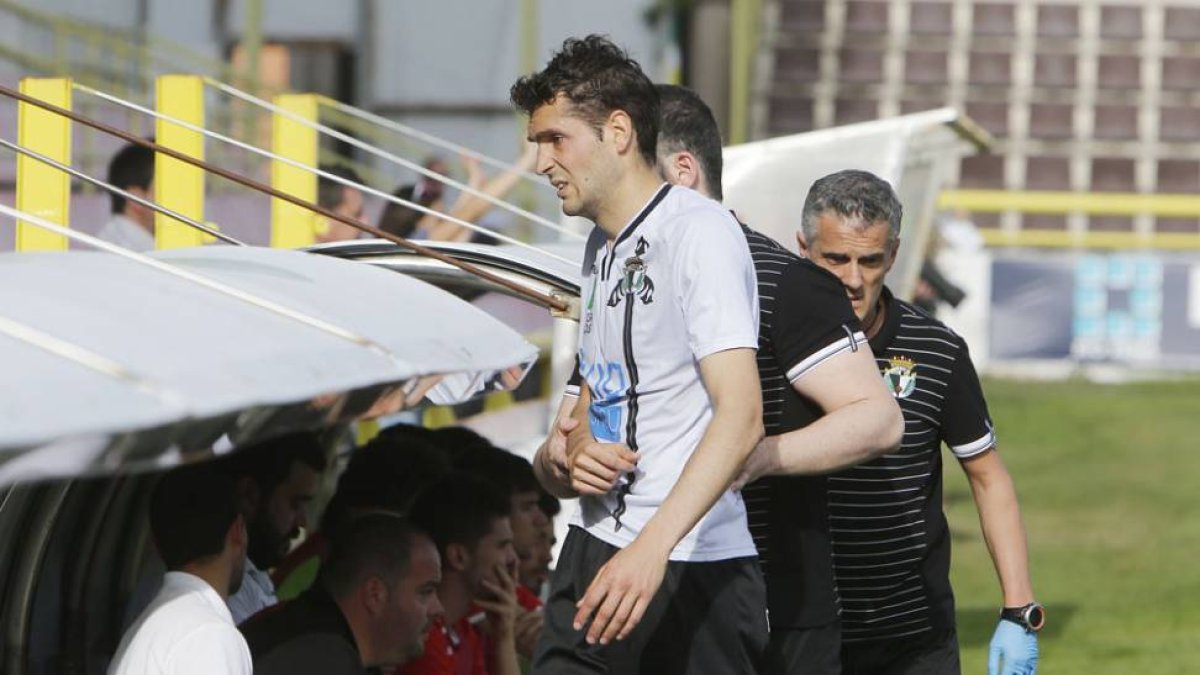 Gabri Ortega se retira del terreno de juego atendido por el médico del Burgos CF-Raúl G. Ochoa