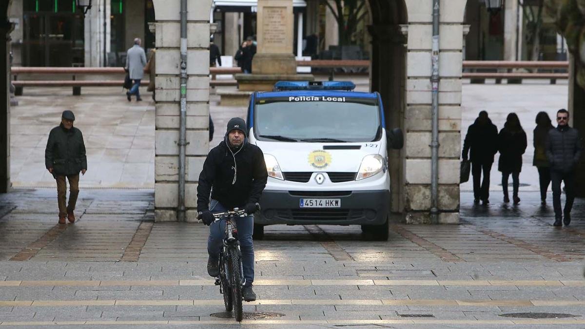 Imagen de un ciclista circulando ayer por el Espolón con una furgoneta de la Policía Local al fondo.-RAÚL G. OCHOA