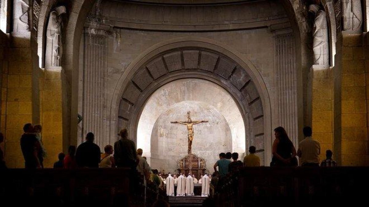 Los monjes benedictinos concelebran una de sus misas diarias en el altar junto al que se encuentra la tumba de Francisco Franco.-JOSÉ LUIS ROCA