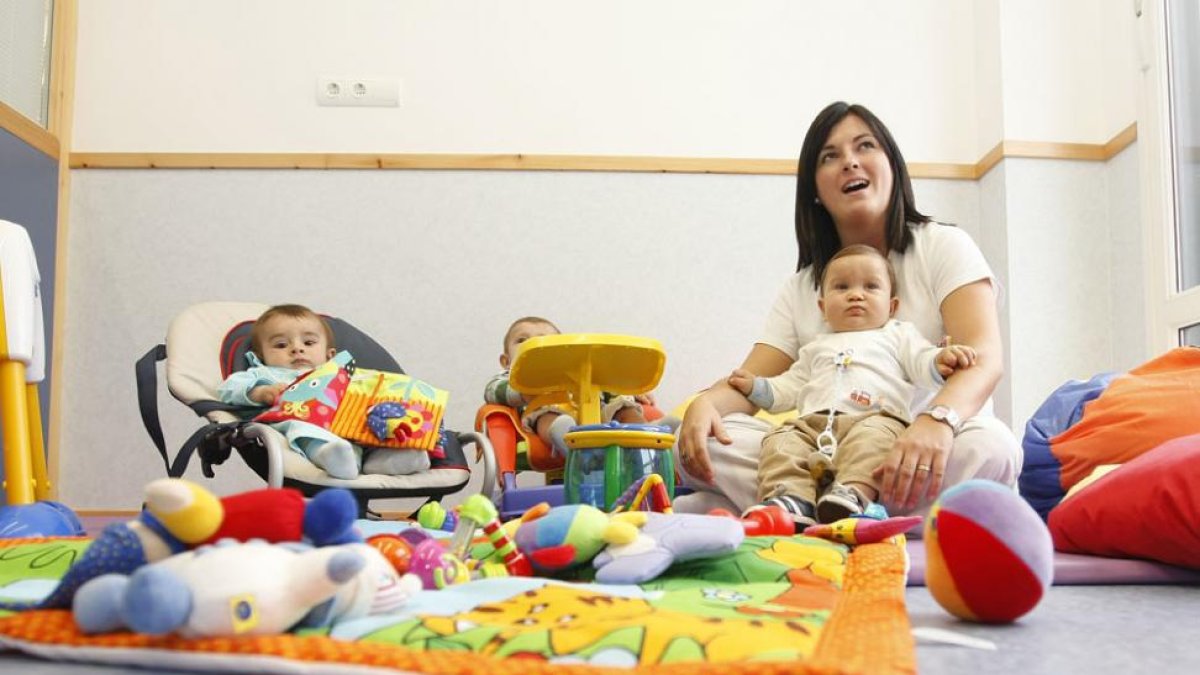 Dos pequeños con su monitora en la guardería de Villalonquéjar.-RAÚL G. OCHOA