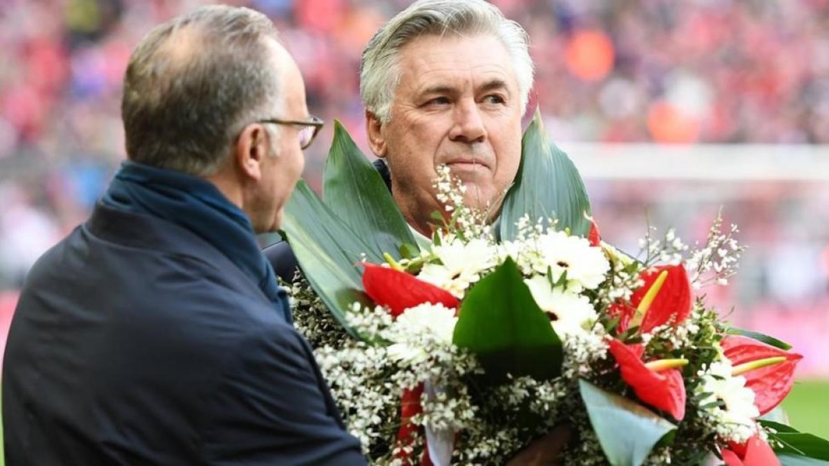 Ancelotti recibe un obsequio de Rummenigge por sus 1000 partidos en los banquillos.-REUTERS / LENNART PREISS