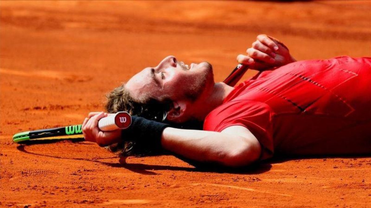 Tsitsipas, tendido en la tierra tras batir a Carreño este sábado.-EFE / ALEJANDRO GARCÍA