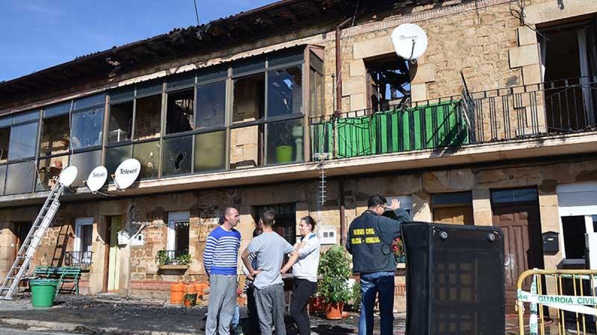 La Policía Judicial realiza su trabajo de investigación. Al lado, vecinos afectados esperando a recuperar algunos de sus muebles.-R.F.
