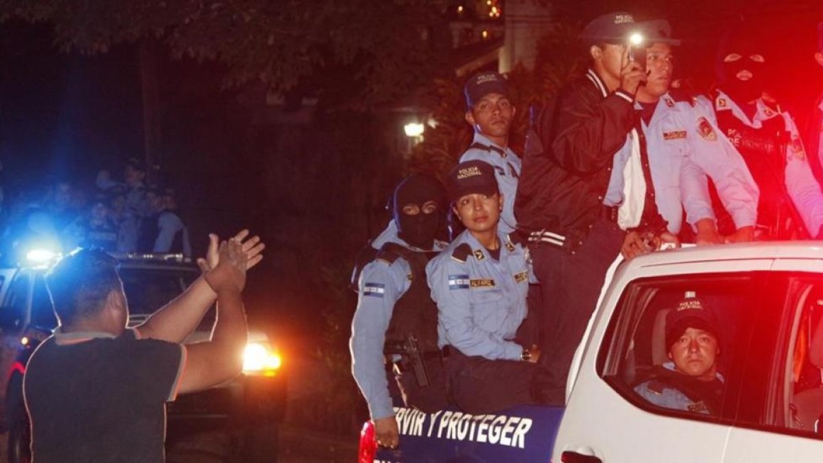 Vecinos de Tegucigalpa aplauden al paso de policías que se niegan a aplicar el estado de emergencia.-/ FERNANDO ANTONIO / AP