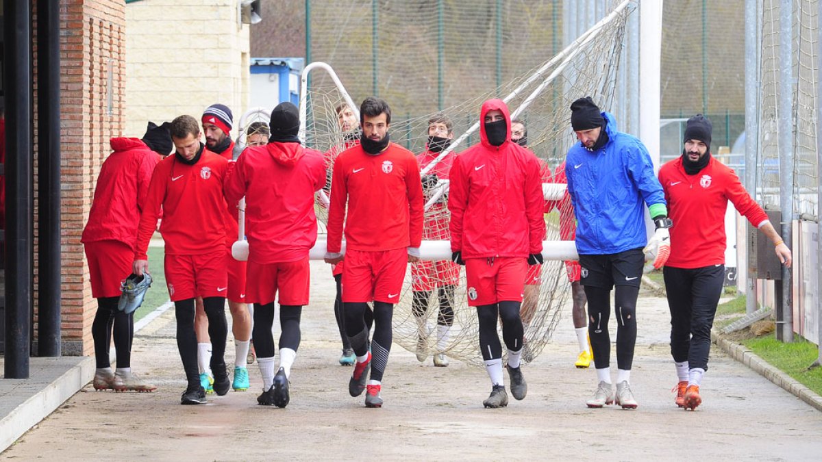 Los jugadores del Burgos CF trasladan un portería en la Ciudad Deportiva de Castañares. ISRAEL L. MURILLO