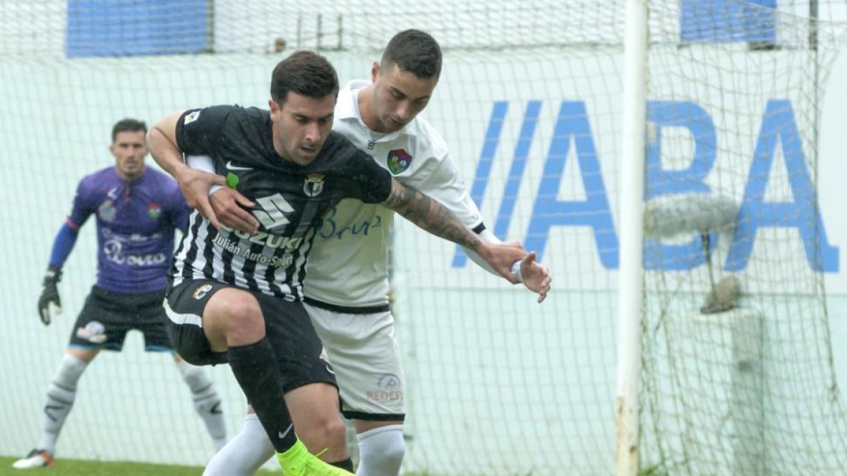 El ariete del Burgos CF Adrián forcejea con un defensor del Boiro en el choque de ayer en Barraña-Javier Triñanes