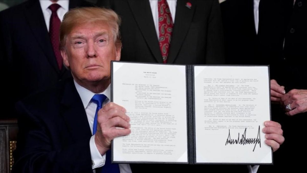 Donald Trump muestra su firma en el mermorándum sobre China. /-JONATHAN ERNST