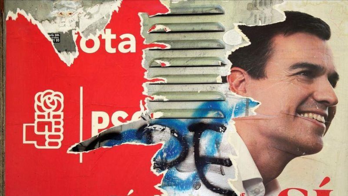 Uno de los carteles que los socialistas utilizaron en campaña electoral, ahora deteriorado, con la imagen de Pedro Sánchez.-REUTERS