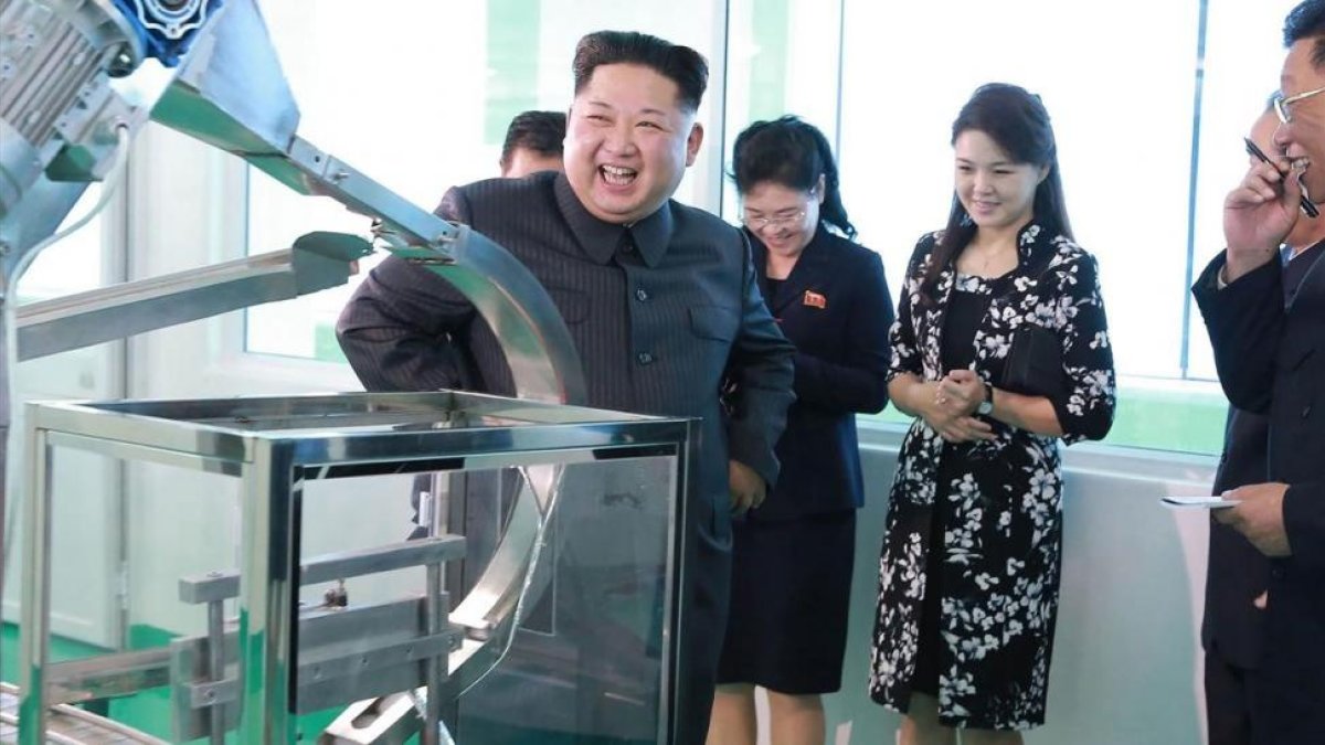 Kim Jong-un durante la visita a la fábrica, junto a su mujer, Ri Sol-ju (segunda por la derecha), en una foto difundida el domingo por la KCNA.-AFP / KCNA