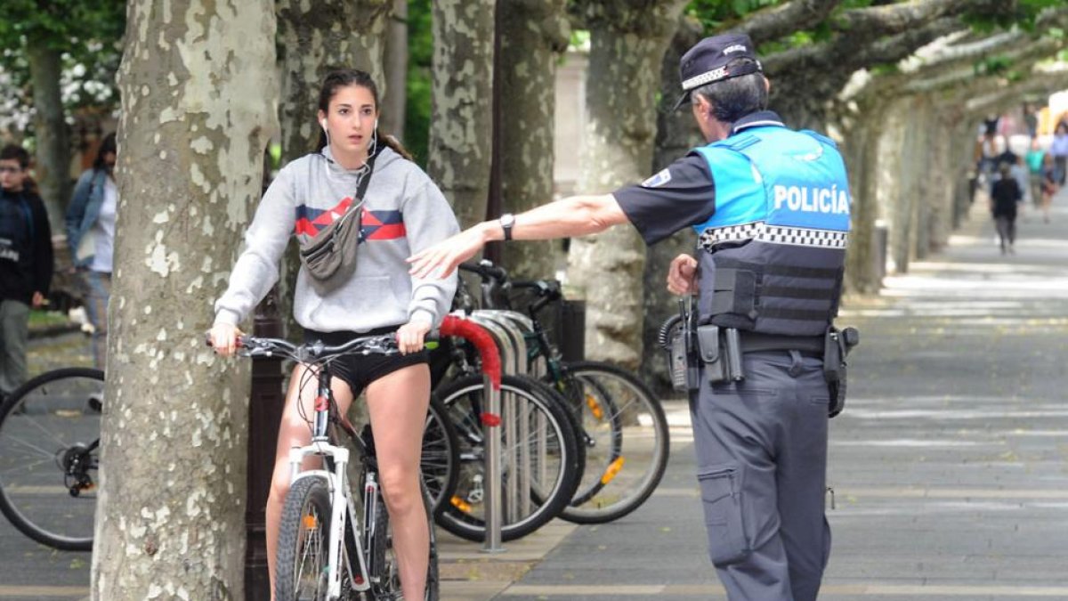 Un agente para a una joven ciclista que transitaba por el Espolón.-ISRAEL L. MURILLO