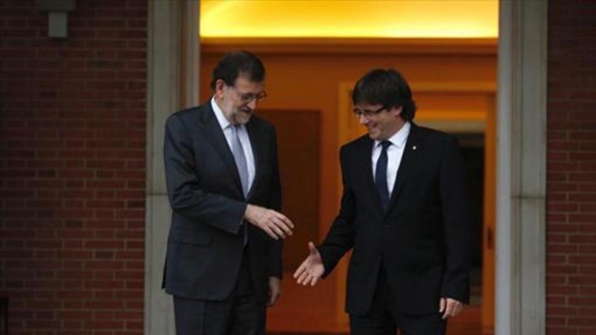 Rajoy y Puigdemont se saludan en la puerta de la Moncloa, en abril del pasado año.-DAVID CASTRO