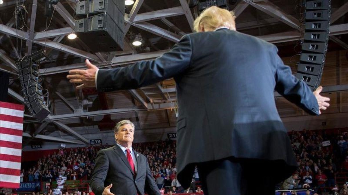 Trump saluda al presentador de televisión Sean Hannity en un mitin en Cape Girardeau, en Misuri, este lunes.-JIM WATSON (AFP)