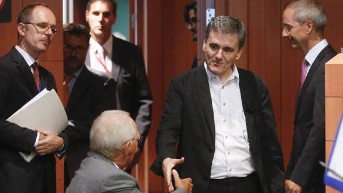 El ministro de Finanzas griego, Euclides Tsakalotos (derecha) estrecha la mano de su homólogo alemán, Wolfgang Schäuble, este viernes, en Bruselas.-Foto: EFE / OLIVIER HOSLET