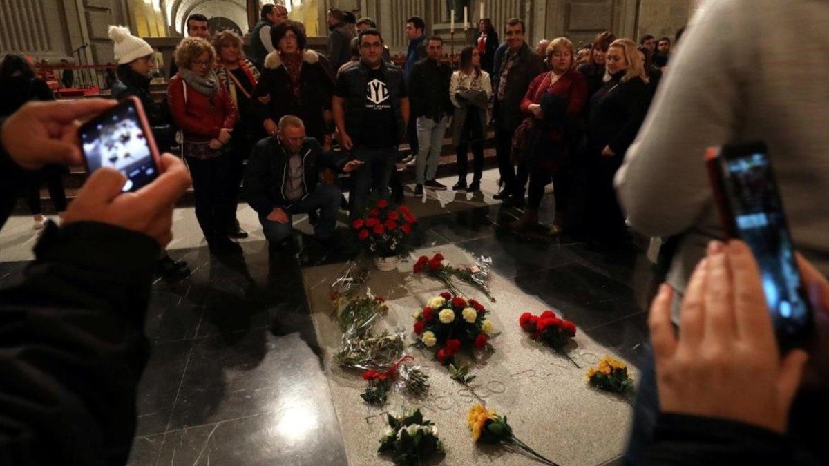 Varios ciudadanos posan ante la tumba de Franco en el Valle de los Caídos, este sábado.-SUSANA VERA (REUTERS)