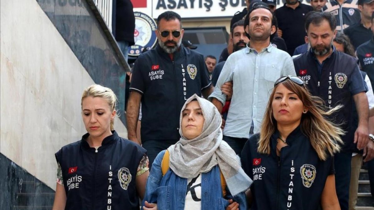 La policía escolta a una periodista detenida ante el juez en Estambul.-ALI AKSOYER