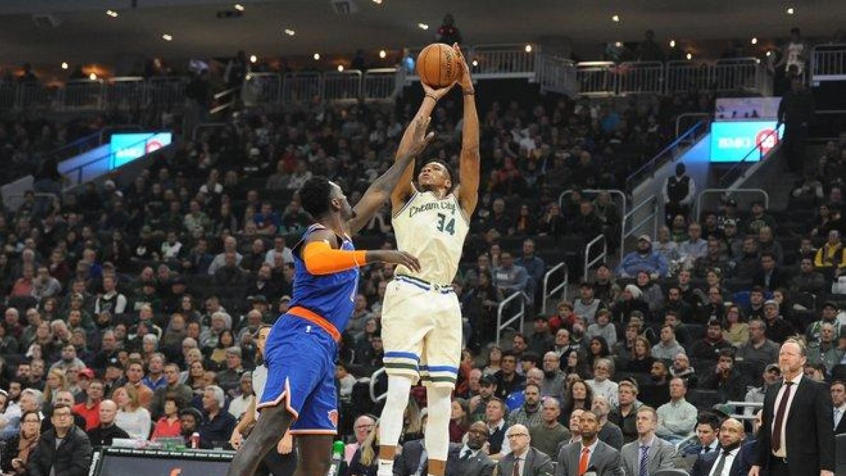 Giannis Antetokounmpo trata de encestar ante la oposición de Bobby Portis.-