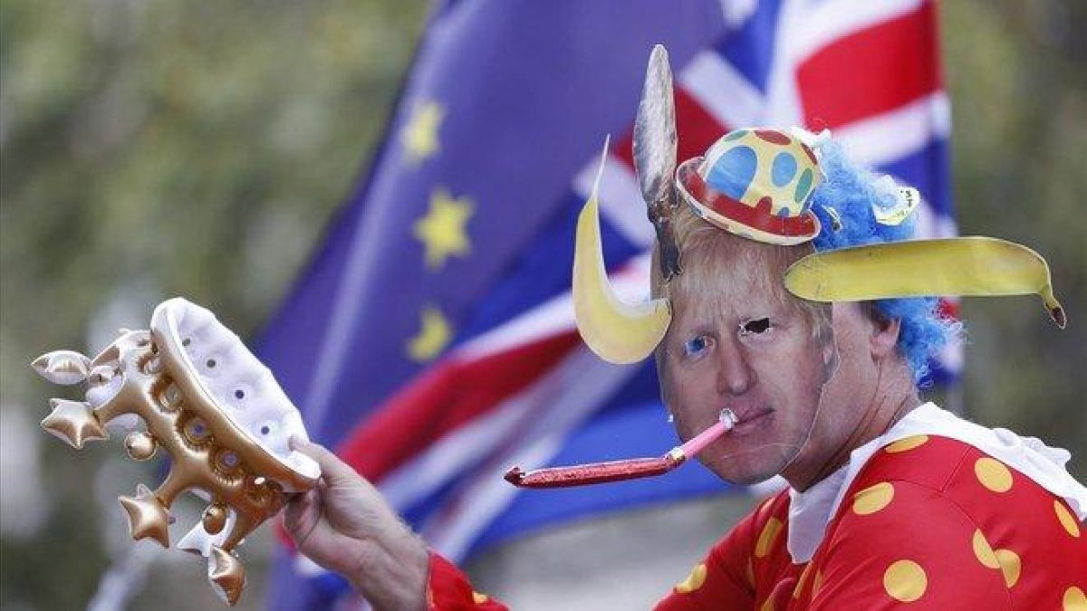 Un contrario al ’brexit’ se manifiesta en Londres con una careta de Johnson, este jueves.-AP / ALASTAIR GRANT