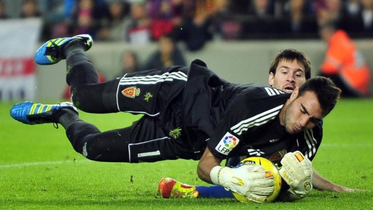 Roberto, ante Messi, en la temporada 2011-12, cuando el portero jugaba en el Zaragoza.-AP / MANU FERNÁNDEZ