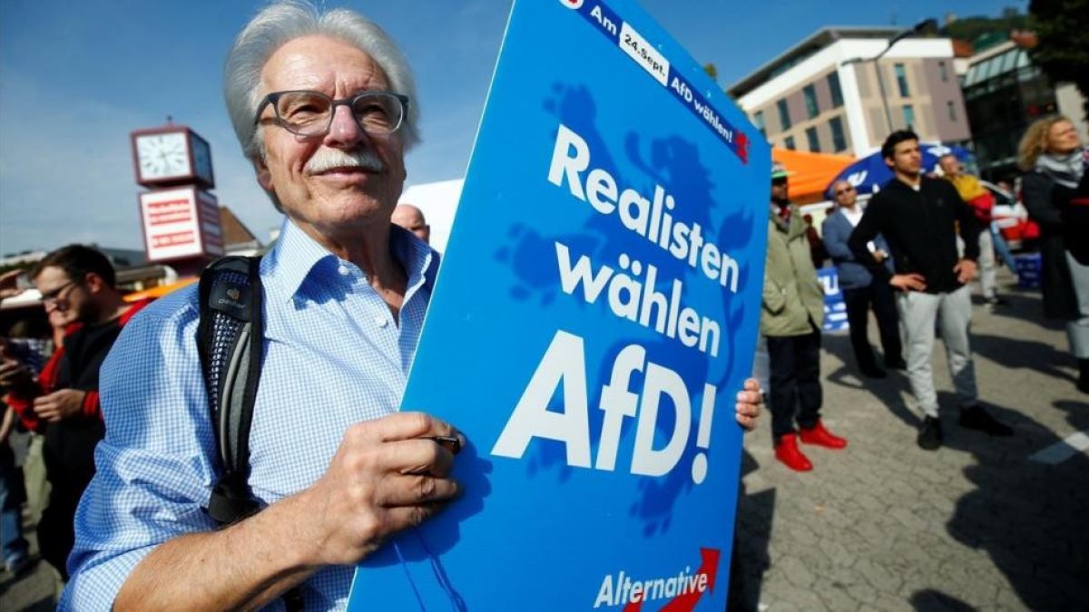 Miembros de AfD protestan en un acto electoral de Merkel, en Happenheim, este viernes-REUTERS / RALPH ORLOWSKI