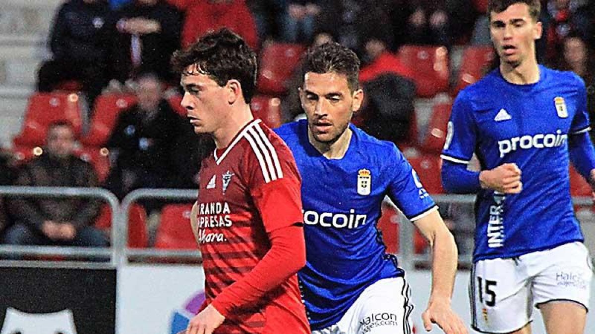 Guarrotxena conduce un balón ante el acoso de un jugador del Real Oviedo-Alfonso G. Mardones