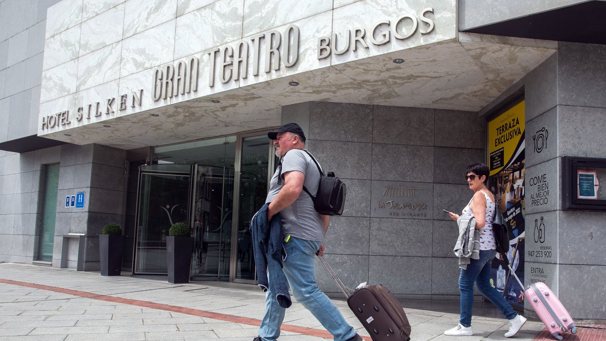 Dos personas pasan con sus maletas por delante de un establecimiento hotelero de la capital burgalesa. TOMÁS ALONSO
