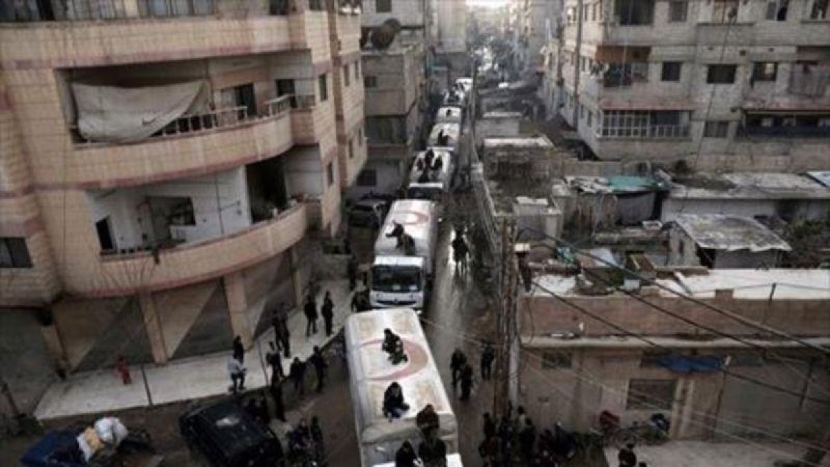 Convoy de ayuda humanitaria por las calles de Kafr Batna.-AFP / AMER ALMOHIBANY