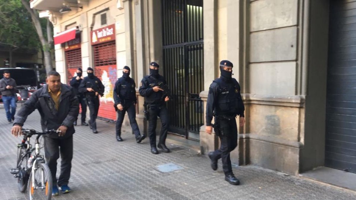 Agentes de los Mossos en Viladomat 40 de Barcelona, donde se ha practicado un registro.-GUILEM SÁNCHEZ