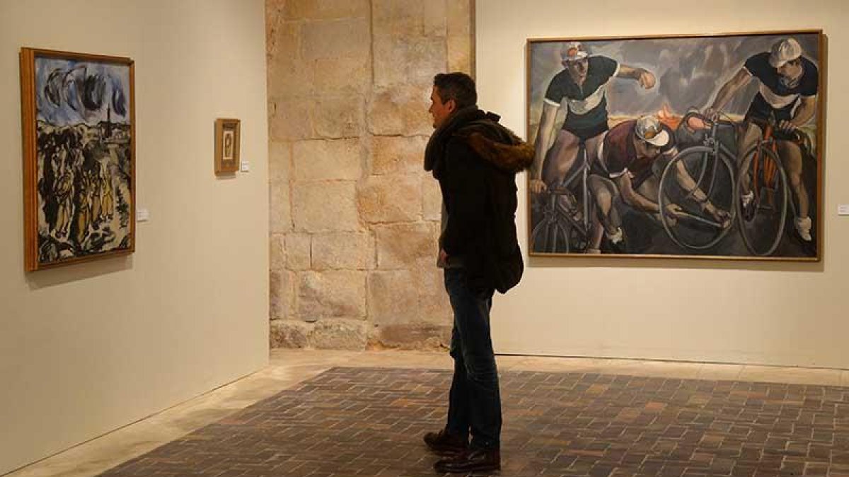 Un visitante observa una de las pinturas y da la espalda a esta imagen de ciclistas que hacía más de setenta años que no se mostraba.-Ricardo Ordóñez (ICAL)