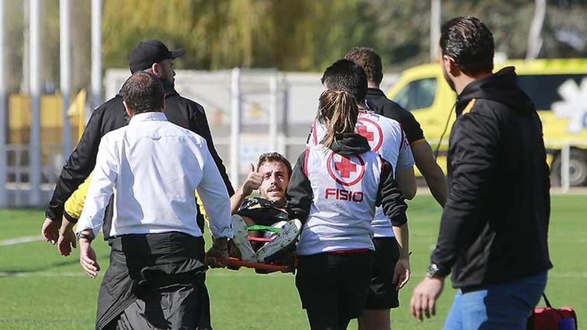 Álvaro González lanza un mensaje de tranquilidad mientras abandona el terreno de juego en camilla en el descanso del partido de ayer.-RAÚL OCHOA
