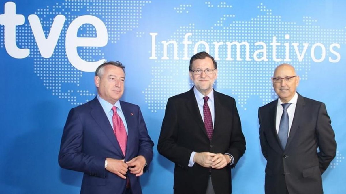 Mariano Rajoy, entre José Antonio Sánchez, presidente de RTVE, y José Antonio Sánchez Gundín, director de los Servicios Informativos de TVE.-EL PERIÓDICO