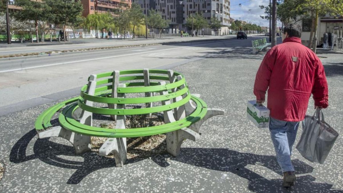 Un hombre pasa junto a uno de los bancos rotos ubicado en el bulevar.-ISRAEL L. MURILLO