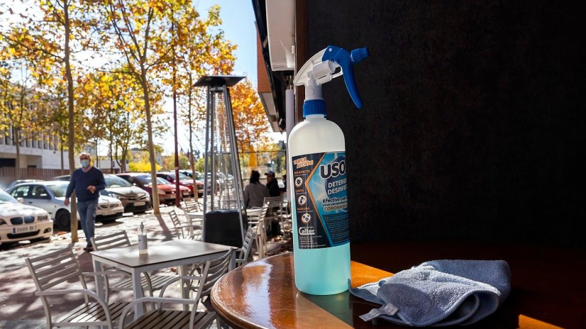Un bote de gel hidroalcohólico sobre una mesa de la terraza un bar. PHOTOGENIC / PABLO REQUEJO