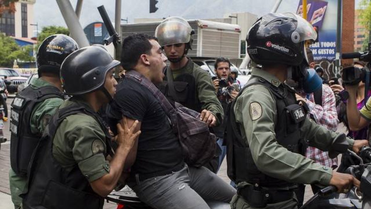 Imagen de archivo de miembros de la Guardia Nacional Bolivariana de Venezuela, detieneniendo a un joven en 2012.-EFE / MIGUEL GUTIÉRREZ