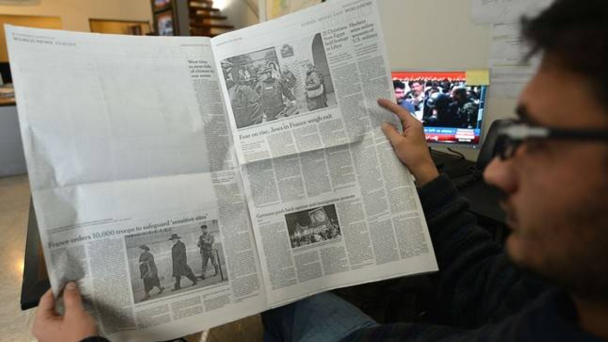 Un paquistaní lee la edición local de 'The New York Times', en la que ha sido eliminada la información sobre 'Charlie Hebdo', este miércoles en Islamabad.-Foto: AFP / AAMIR QURESHI