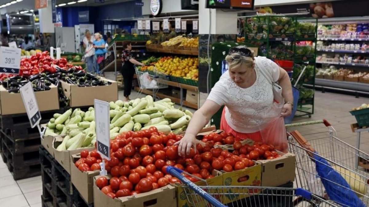 Una mujer compra tomates en un supermercado de Moscú.-YURI KOCHETKOV