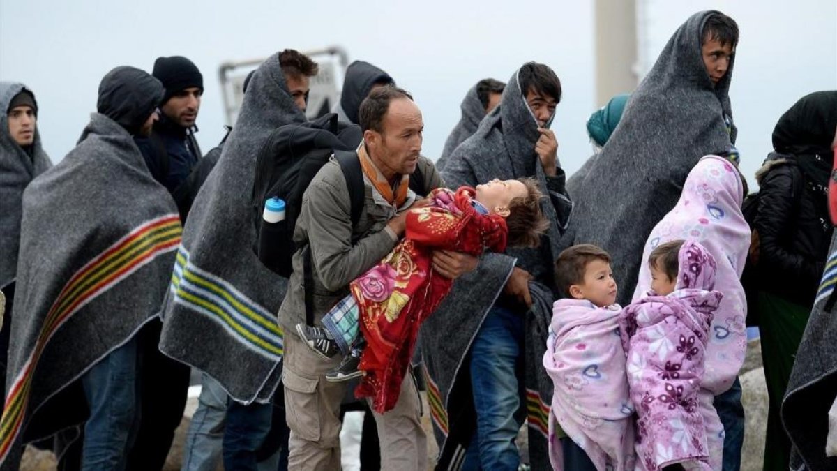 Refugiados se cubren con mantas tras cruzar la frontera entre Hungria y Austria en Nickelsdorf,  Austria, en septiembre del 2015.-EFE / ROLAND SCHLAGER