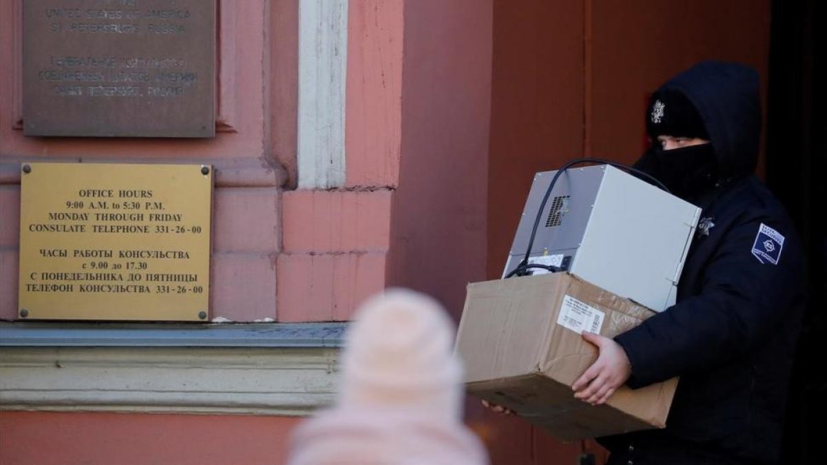 Un agente de seguridad carga con varias cajas a su salida del Consulado General de EEUU en San Petersburgo.-EFE