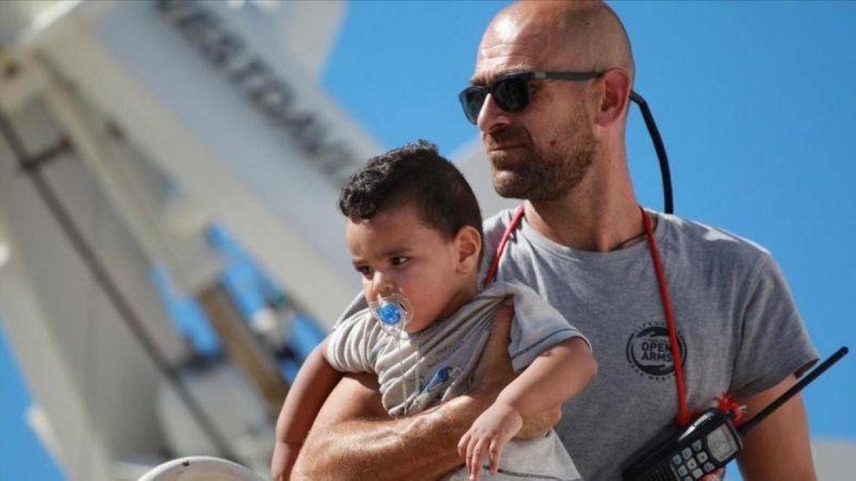 Un voluntario de Open Arms con un niño durante un desembarco en Agirento (Sicilia).-EFE / MONTANA