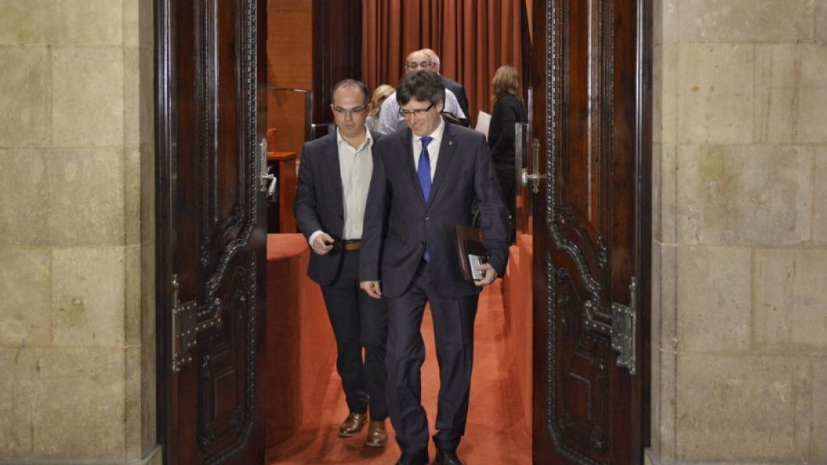 Carles Puigdemont y Jordi Turull salen de la reunión de Junts pel Sí antes del pleno del Parlament, este miércoles.-FERRAN SENDRA
