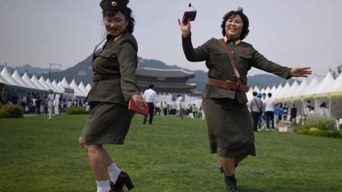 Desertoras de Corea del Norte bailan con uniformes militares de su país de origen en una exposición por la unificación de las dos Coreas, en Seúl, este viernes.-Foto: AFP / ED JONES