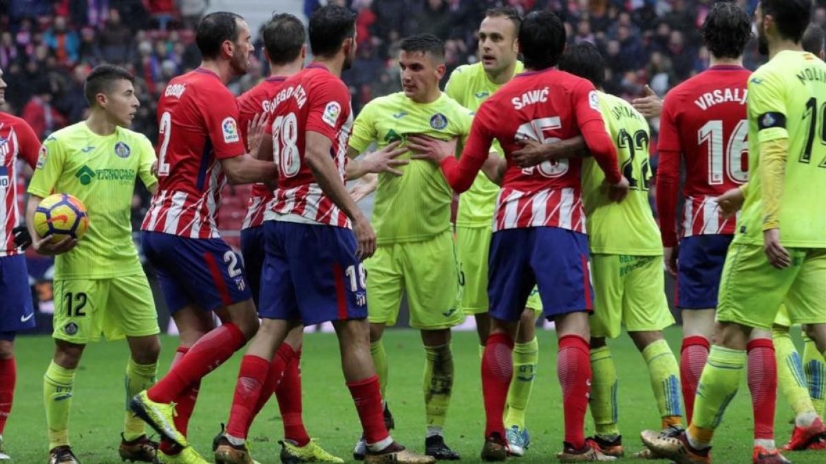 Jugadores del Atlético y Getafe, en uno de los múltiples enfrentamientos durante el partido.-EFE