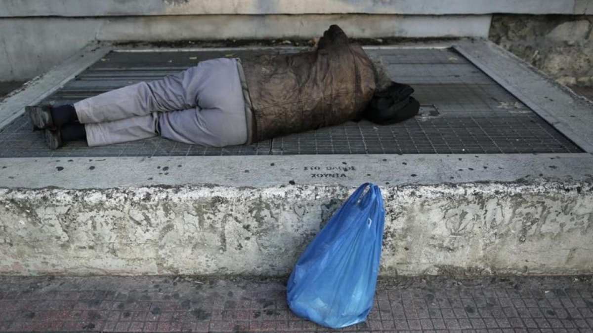 Una persona 'sintecho' duerme en la calle.-AP
