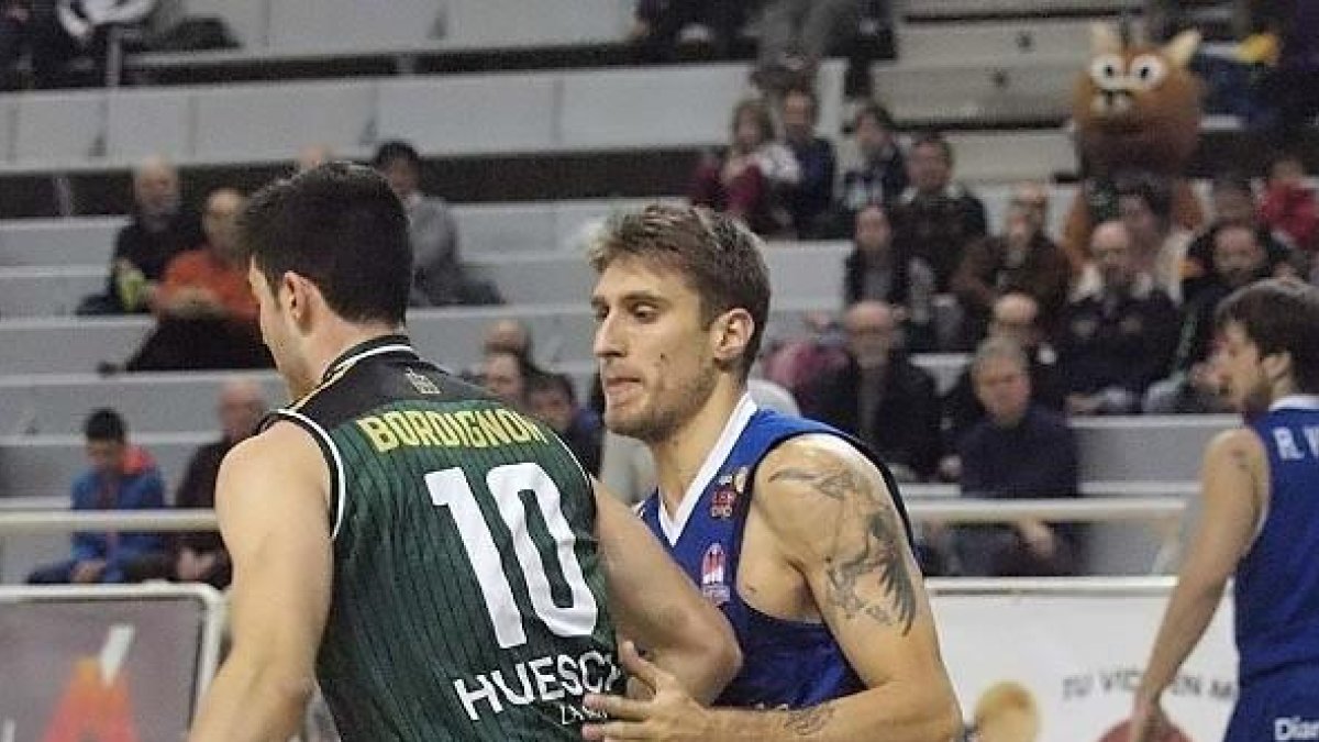 Javi Vega frena el avance del jugador de Bordignon, ayer, en Huesca.-C. PASCUAL / PEÑAS DE HUESCA