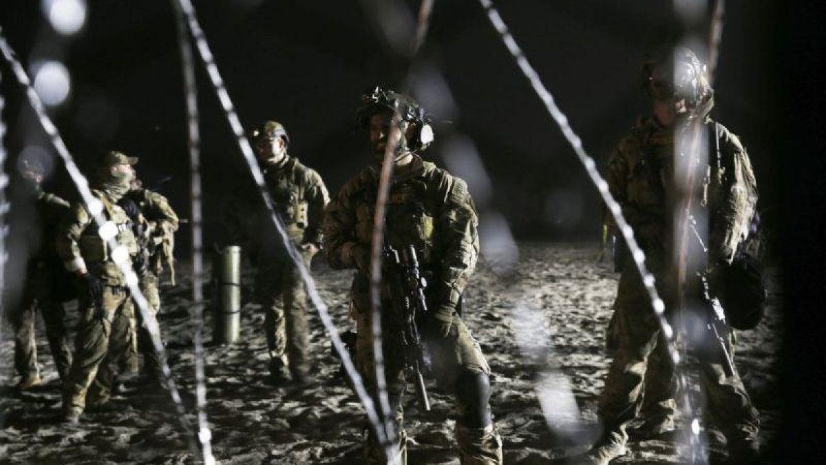 Agentes de la patrulla de fronteras de EEUU, junto a la valla que les separa de Tijuana.-AP