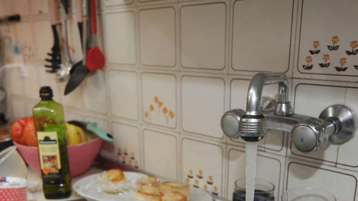 Una persona friega vasos y platos en la cocina de su casa.-ISRAEL L. MURILLO