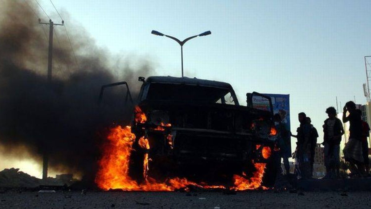 Yemenís se reúnen cerca de un vehículo incendiado propiedad de combatientes Huthi.-Foto: EFE