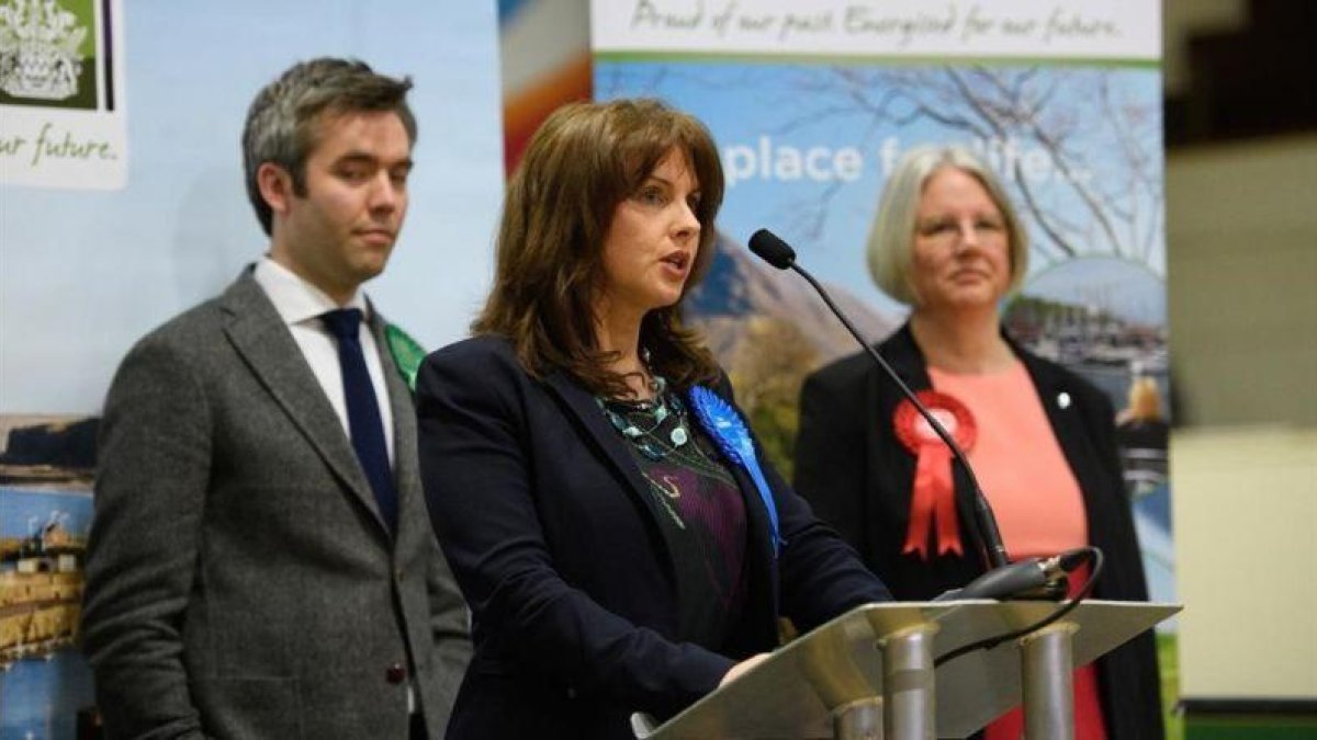 Trudy Harrison (centro) comparece tras su victoria en las elecciones en Copeland, rodeado por el candidato del Partido Verde (izquierda) y la laborista Gillian Troughton, en Whitehaven (Inglaterra), el 24 de febrero.-GETTY IMAGES / LEON NEAL