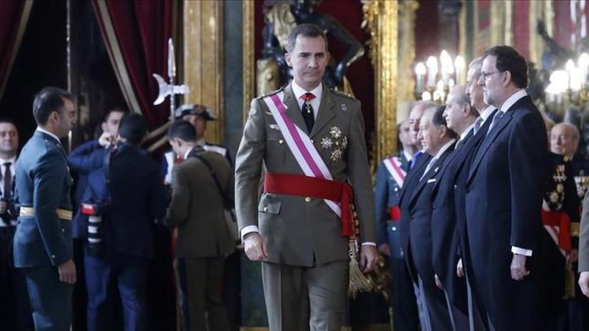 El Rey pasa junto al presidente en funciones, Mariano Rajoy, y otros miembros del Gobierno, este miércoles durante la Pascua Militar.-POOL